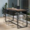 standing work table in walnut finish setup in an open meeting environment with four tall chairs