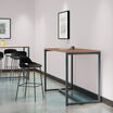 standing work table in walnut finish setup in an open workspace environment with a tall side chair and laptop in use on top of the table